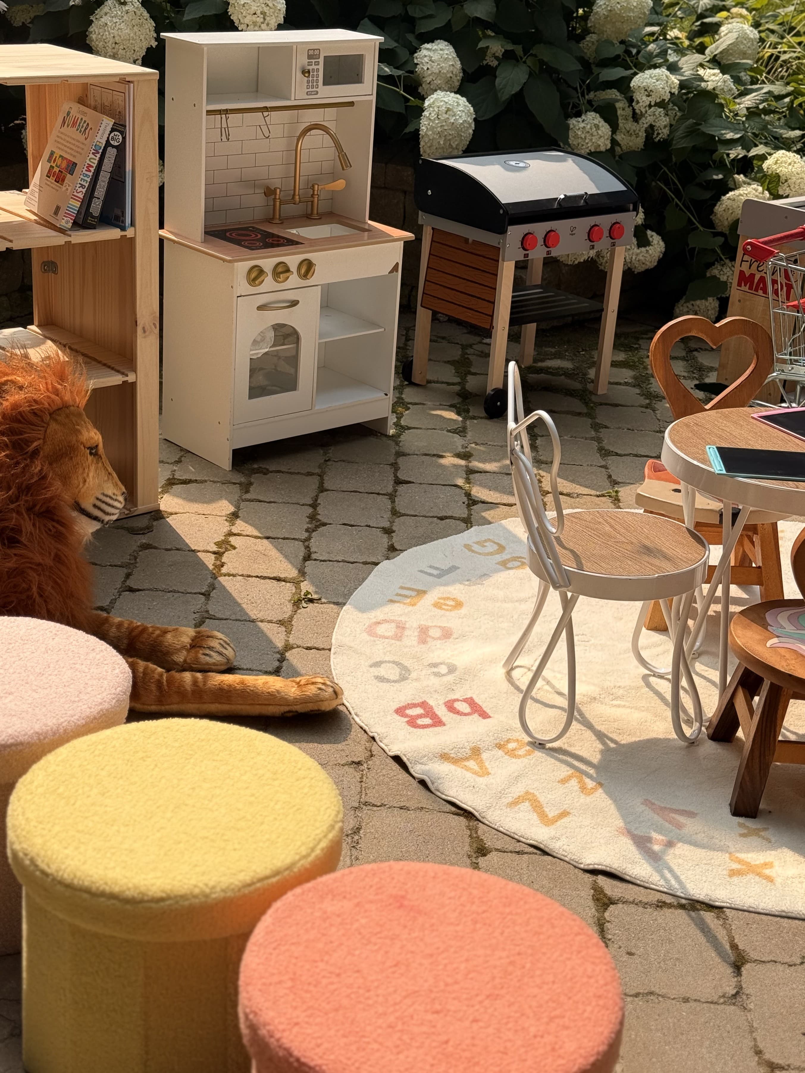 Pretend play kitchen station with toy grill and plush lion at kids event